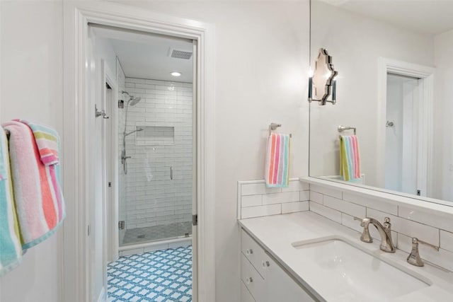 bathroom featuring vanity, an enclosed shower, and decorative backsplash