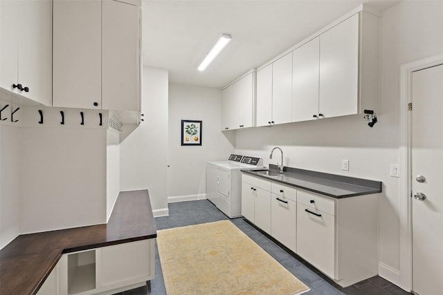 laundry room with cabinets, washer and clothes dryer, and sink