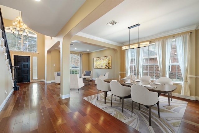 dining space featuring crown molding, dark hardwood / wood-style flooring, and a notable chandelier