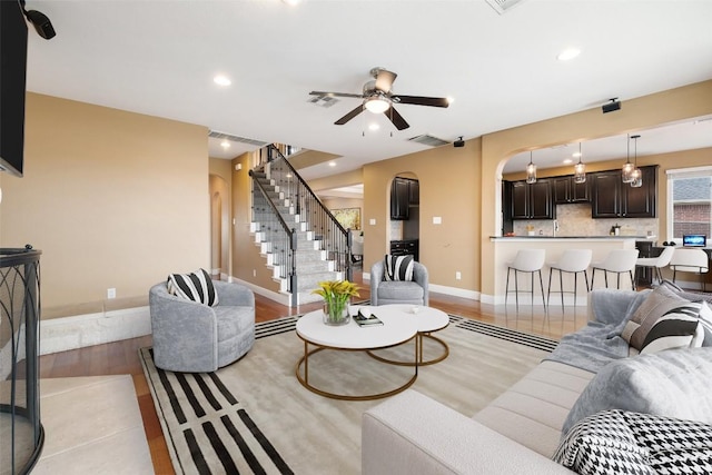 living room featuring ceiling fan and light hardwood / wood-style floors