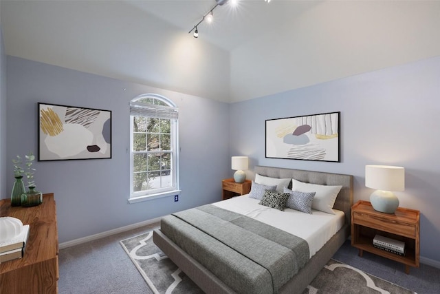 carpeted bedroom featuring lofted ceiling and track lighting