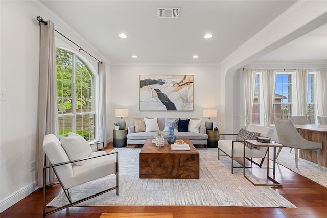 living area with crown molding, wood finished floors, baseboards, visible vents, and recessed lighting