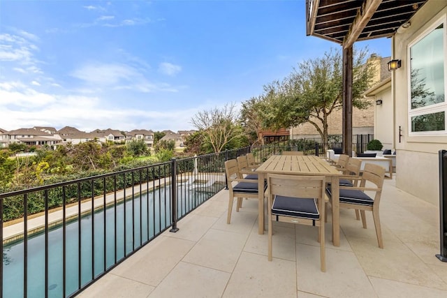 balcony with a patio area, outdoor dining area, and a residential view