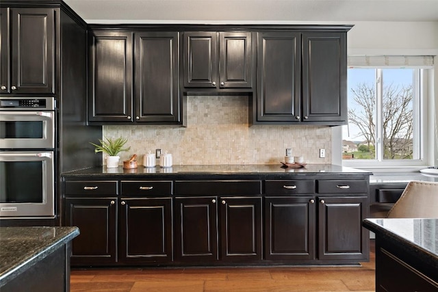 10709 Pointe View Dr, Austin, TX 78738 - kitchen featuring stainless steel double oven, tasteful backsplash, and dark stone counters