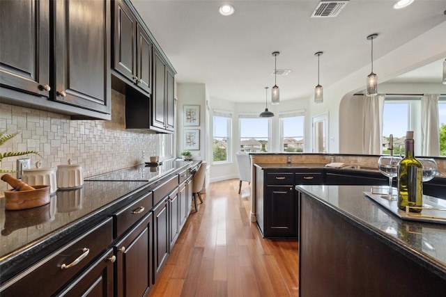kitchen with a wealth of natural light, tasteful backsplash, visible vents, and recessed lighting