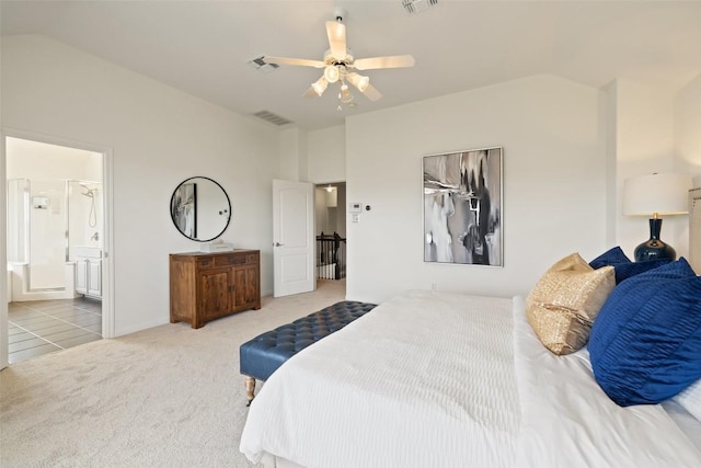 bedroom with lofted ceiling, light carpet, ensuite bathroom, and visible vents