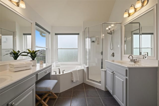bathroom with a sink, a stall shower, a bath, tile patterned flooring, and two vanities