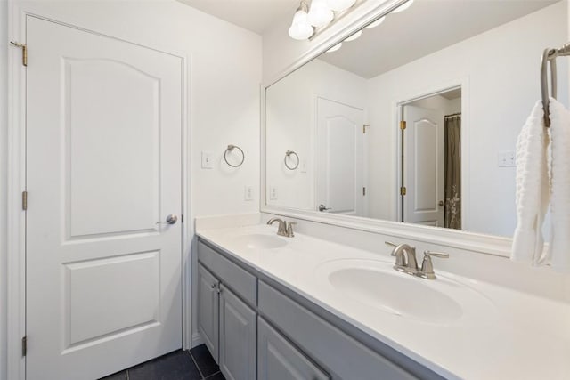 full bathroom with double vanity, tile patterned flooring, and a sink
