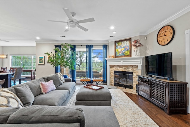 living room featuring crown molding, a fireplace, dark hardwood / wood-style flooring, and ceiling fan