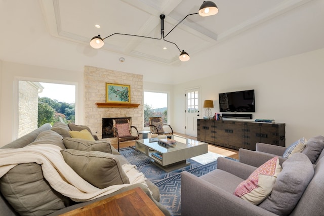 living room featuring beamed ceiling, coffered ceiling, a stone fireplace, and hardwood / wood-style flooring