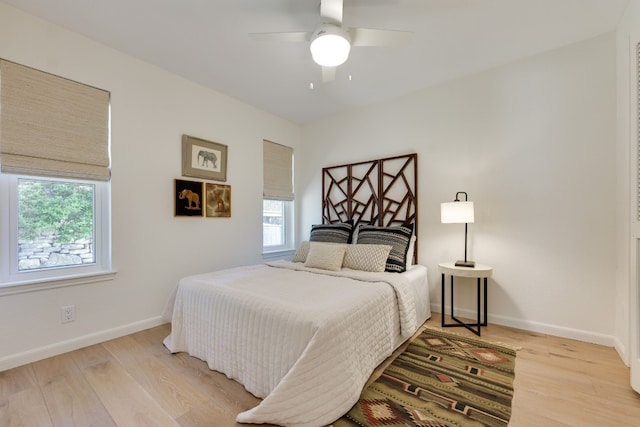 bedroom featuring multiple windows, light hardwood / wood-style floors, and ceiling fan