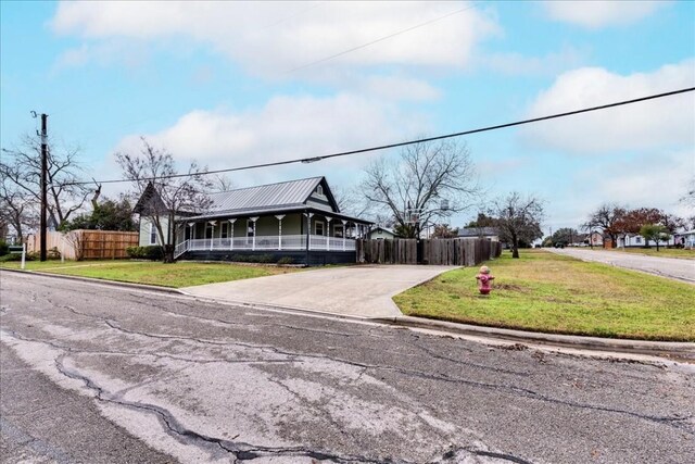 203 W Hall St, Pflugerville, TX 78660 - farmhouse-style home featuring driveway, metal roof, and covered porch
