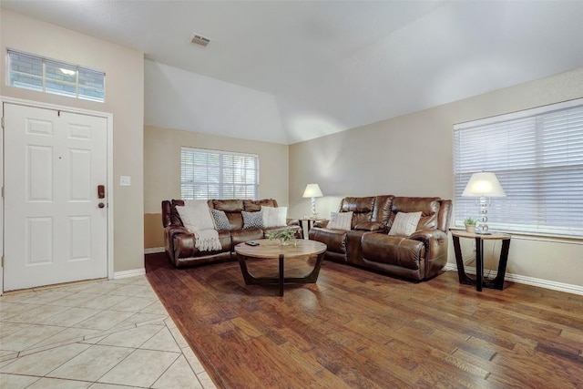 living room featuring lofted ceiling and light hardwood / wood-style flooring