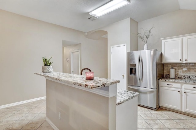 kitchen featuring light stone counters, tasteful backsplash, white cabinets, a kitchen island, and stainless steel fridge with ice dispenser