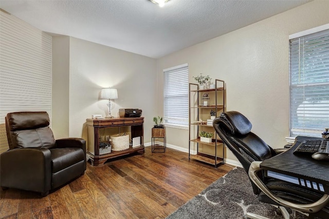 home office with dark hardwood / wood-style floors and a textured ceiling