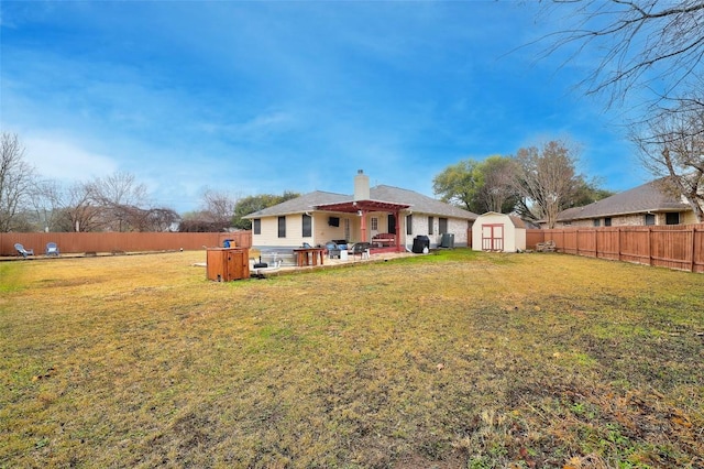 back of property featuring a storage shed, a yard, a hot tub, and a patio