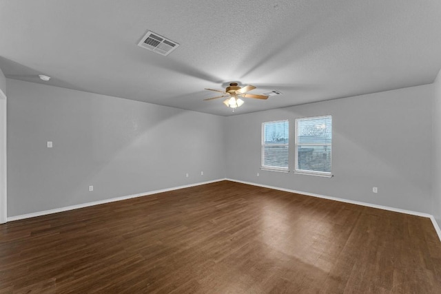 empty room with ceiling fan, dark hardwood / wood-style floors, and a textured ceiling