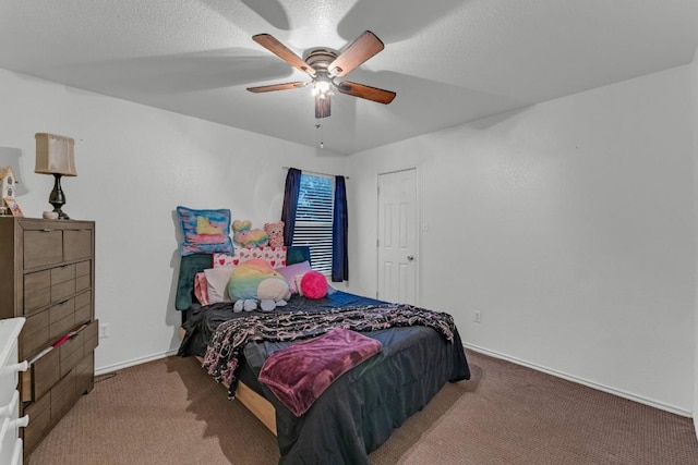 carpeted bedroom featuring ceiling fan and a textured ceiling