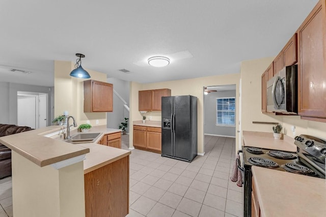 kitchen with decorative light fixtures, black appliances, sink, light tile patterned floors, and kitchen peninsula