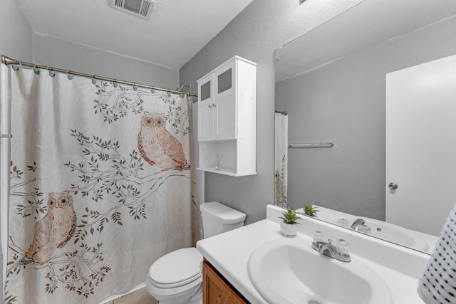 bathroom with vanity, curtained shower, and toilet