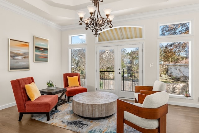 living area featuring dark wood-type flooring, ornamental molding, an inviting chandelier, and french doors