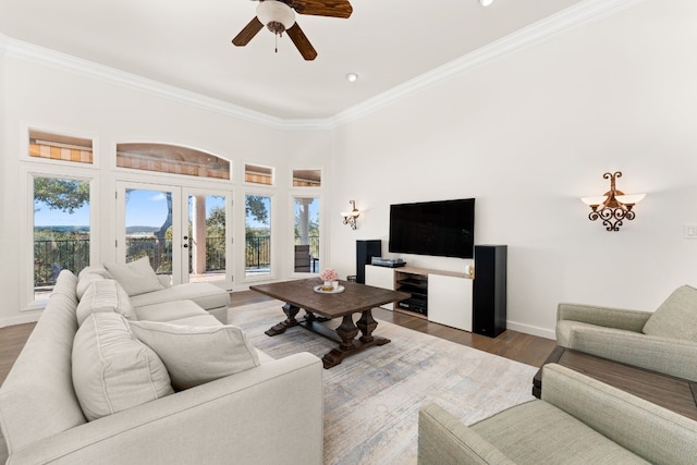 living room with dark wood-type flooring, ornamental molding, and ceiling fan