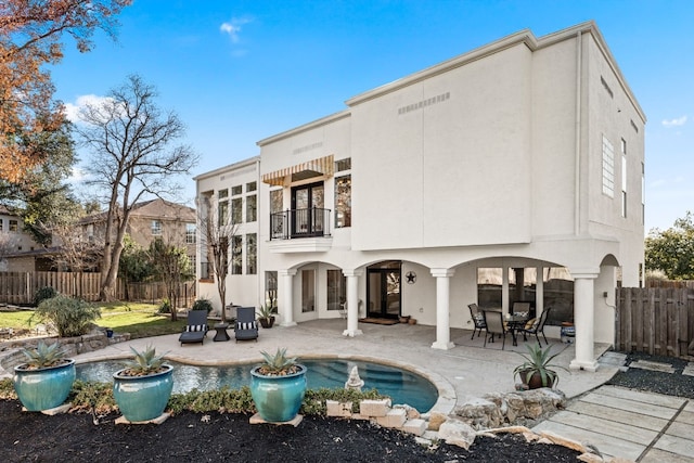 back of house featuring a patio and a balcony