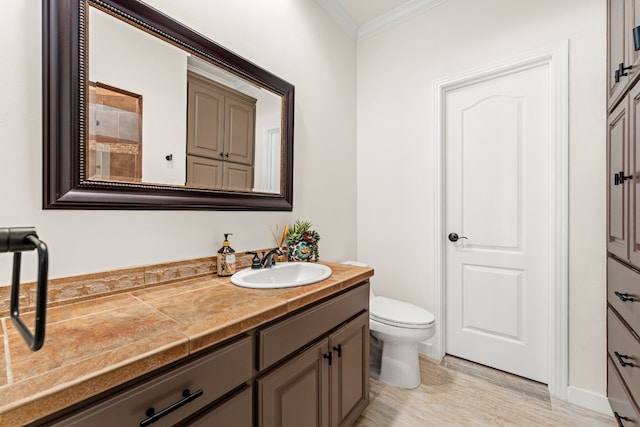 bathroom with hardwood / wood-style flooring, ornamental molding, toilet, and vanity