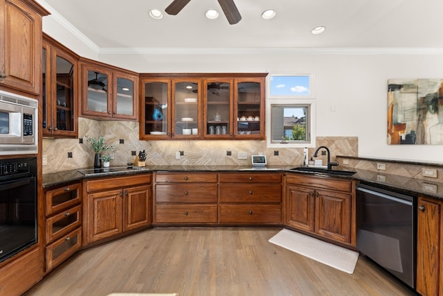 kitchen with sink, tasteful backsplash, ornamental molding, black appliances, and light hardwood / wood-style floors