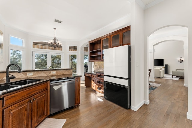 kitchen with pendant lighting, sink, refrigerator, backsplash, and stainless steel dishwasher