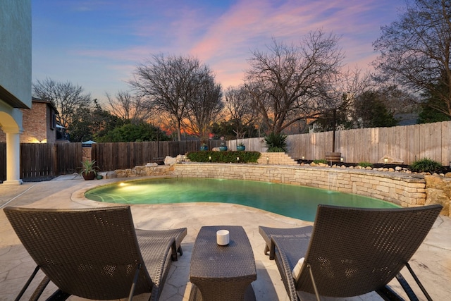 pool at dusk featuring a patio area