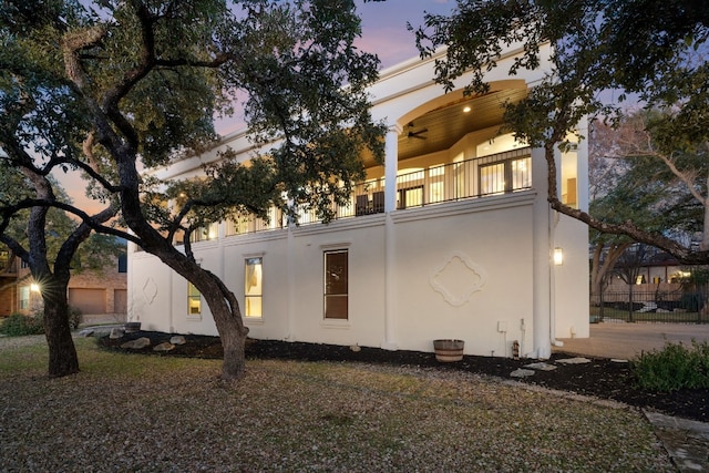 property exterior at dusk featuring a balcony