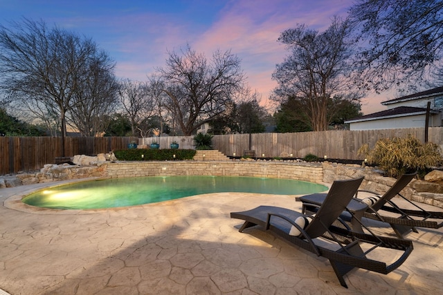 pool at dusk with a patio