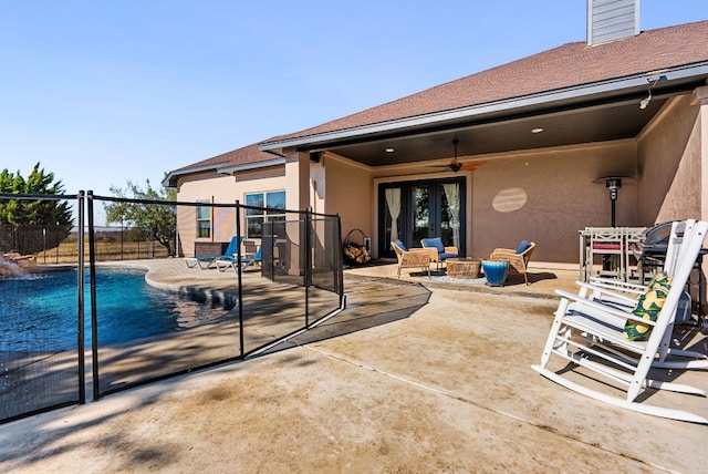 view of swimming pool with ceiling fan, an outdoor fire pit, and a patio area