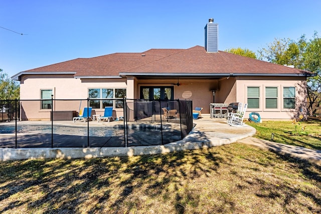 rear view of house featuring ceiling fan, a yard, and a patio