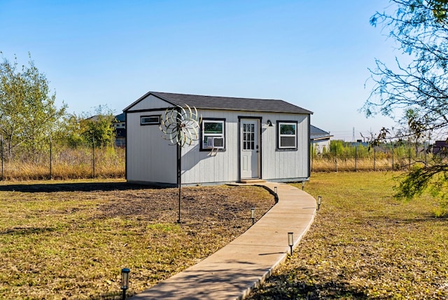 view of outbuilding featuring cooling unit and a lawn