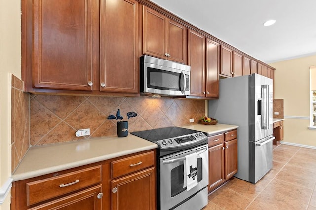 kitchen featuring appliances with stainless steel finishes, light tile patterned floors, and decorative backsplash