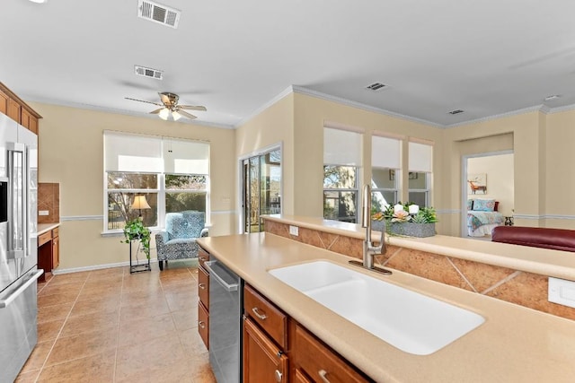 kitchen featuring sink, ornamental molding, light tile patterned floors, ceiling fan, and stainless steel appliances