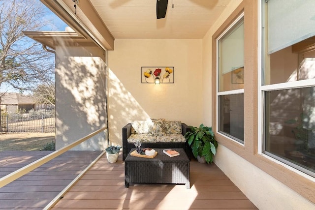 wooden balcony with outdoor lounge area, a deck, and ceiling fan