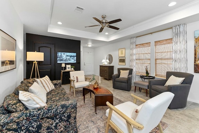 living room featuring ornamental molding, a raised ceiling, and ceiling fan