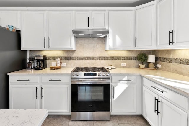 kitchen featuring white cabinetry, decorative backsplash, stainless steel gas range, and light stone countertops