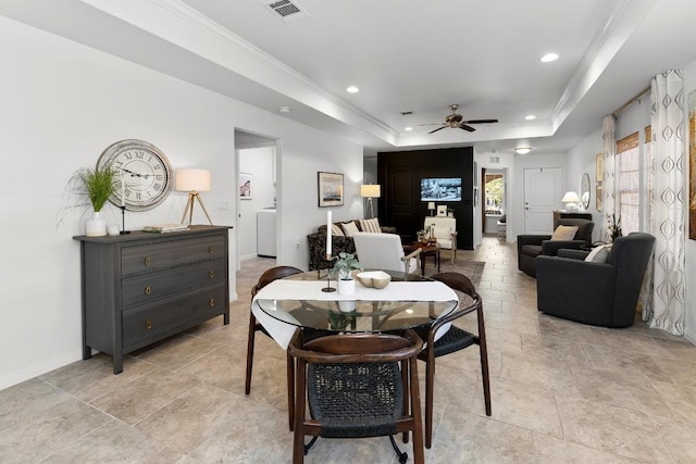 dining space featuring crown molding, a raised ceiling, and ceiling fan