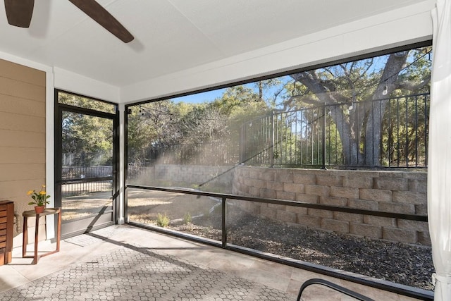 unfurnished sunroom with ceiling fan