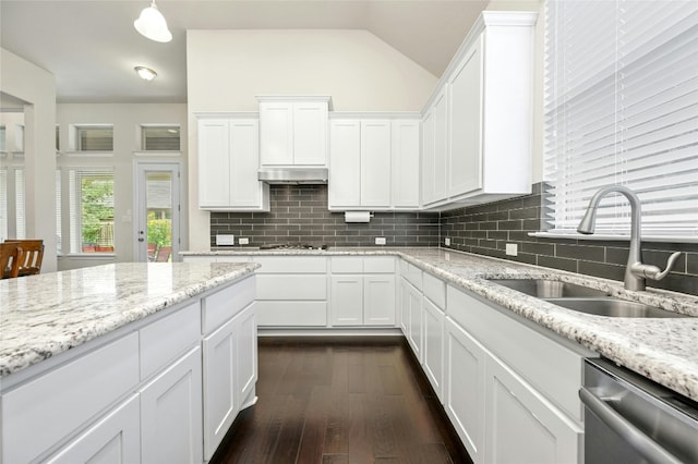 kitchen featuring stainless steel dishwasher, a sink, tasteful backsplash, white cabinetry, and lofted ceiling