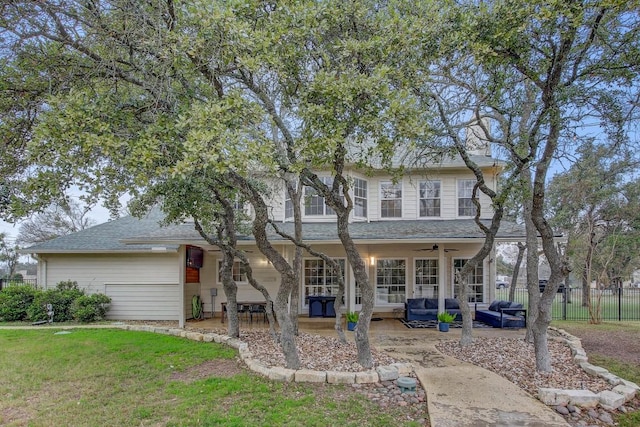 back of house with ceiling fan, outdoor lounge area, a patio area, and a lawn