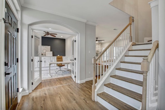 foyer entrance featuring crown molding, ceiling fan, and light hardwood / wood-style floors