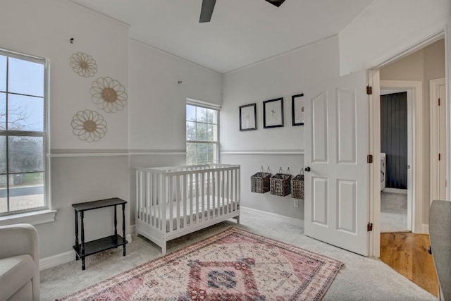 bedroom with a crib and ceiling fan