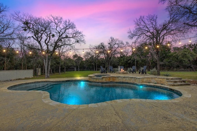 pool at dusk with a lawn, a patio, and an in ground hot tub