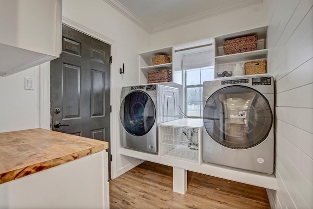 laundry room with crown molding, washing machine and clothes dryer, and light hardwood / wood-style floors