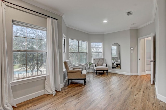 sitting room featuring ornamental molding and light hardwood / wood-style floors